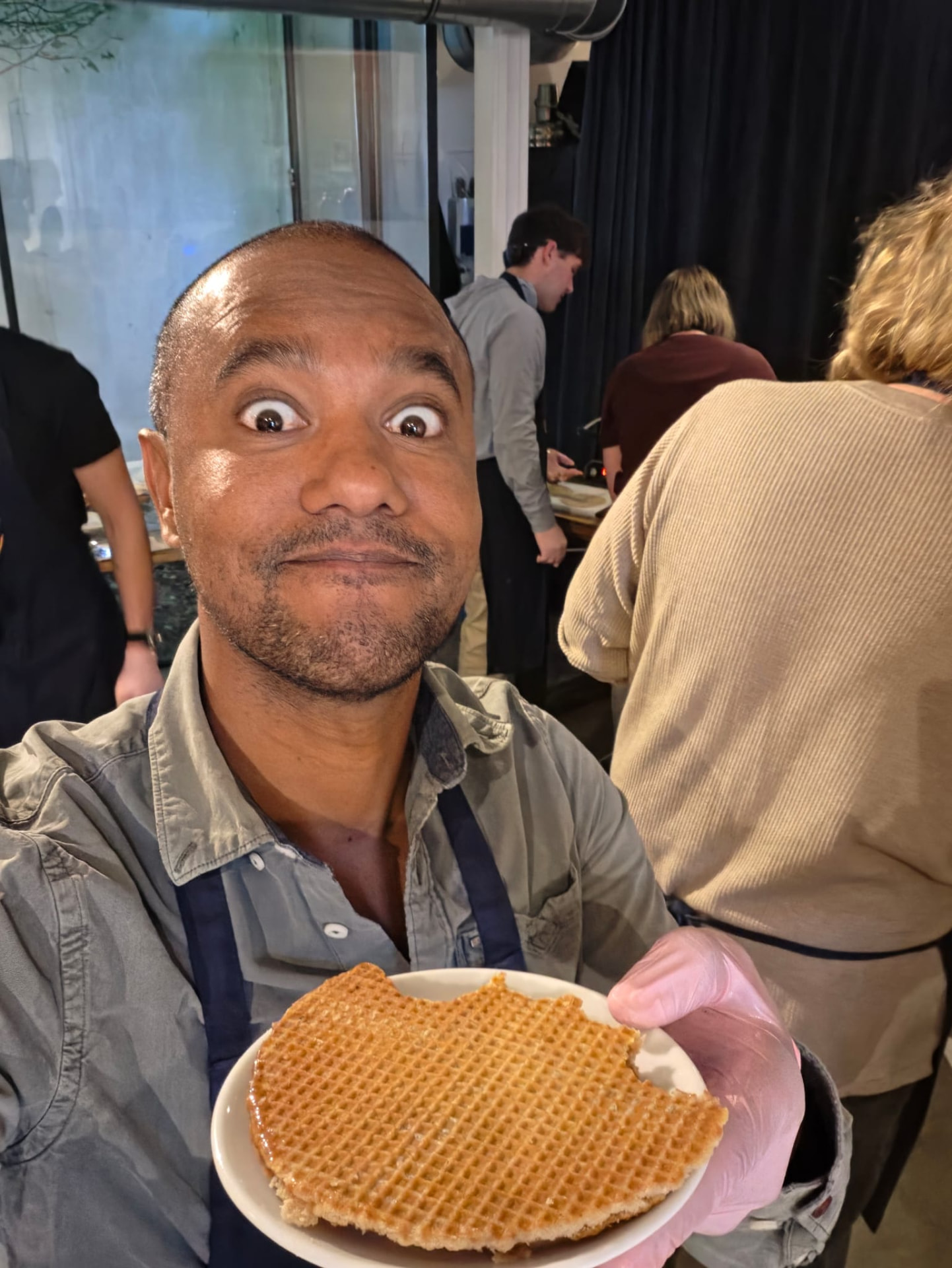 Winley holding a freshly made stroopwafel during an Amsterdam workshop